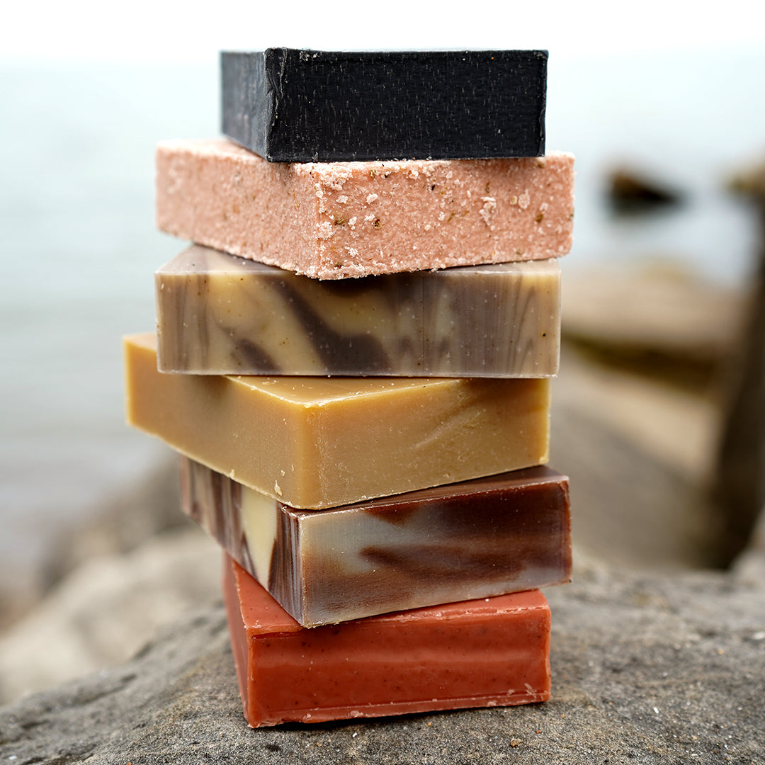 Ręce mieszające naturalne oleje z ługiem w przezroczystej misie na kuchennym blacie