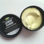 Elegancka buteleczka balsamu do skórek stoi wśród zadbanych paznokci z czerwonym lakierem