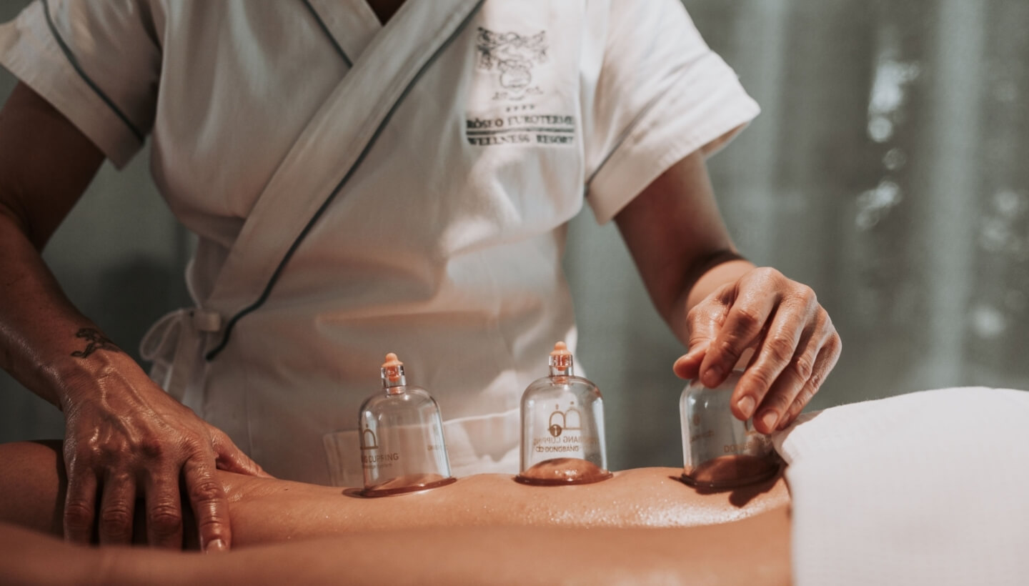 ręce masujące pośladki z bańkami chińskimi w trakcie zabiegu