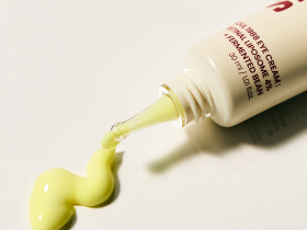 eleganckie białe opakowanie kremu retinal na noc na marmurowym tle z liśćmi