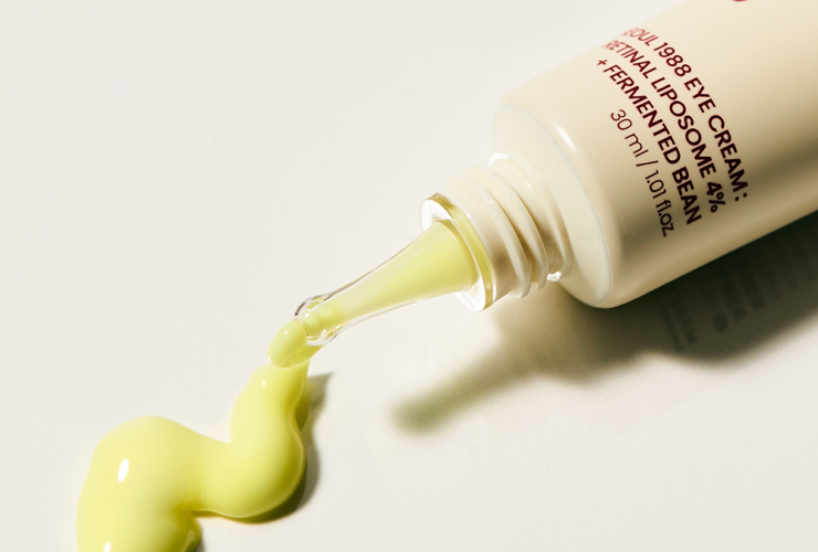 eleganckie białe opakowanie kremu retinal na noc na marmurowym tle z liśćmi